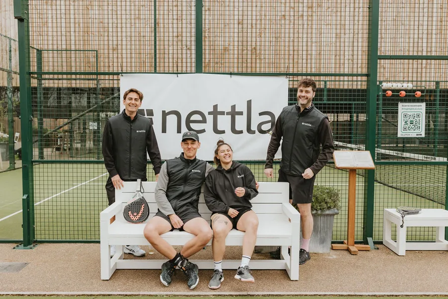 Nettla team in front of the Nettla banner